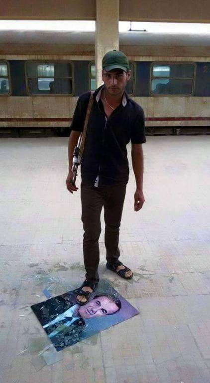 Kurdish Fighter Smashes Picture of Hafez al-Assad; Qamishlo, Syria, June 2015
