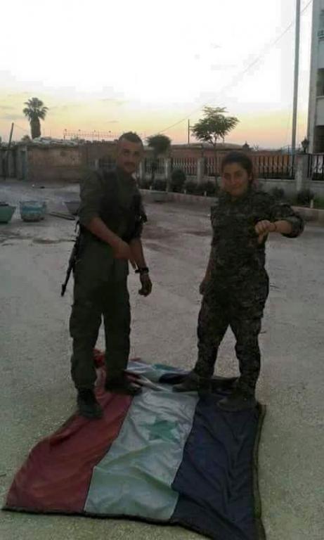 Kurdish Fighters Step on a Syrian Government Flag at a Captured Building in Qamishlo, June 2015