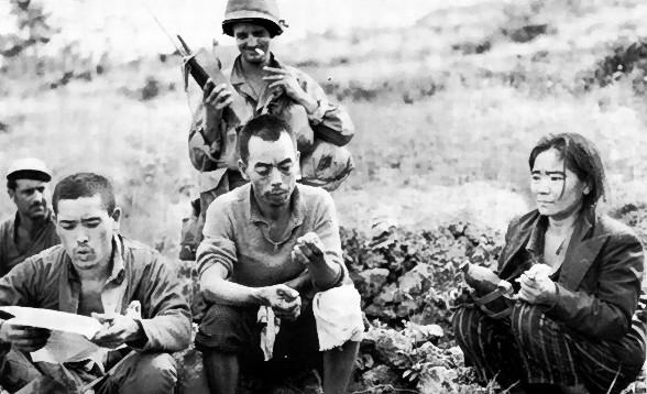 Japanese Civilians Reading US Propaganda Leaflets, Okinawa, Japan, 1945