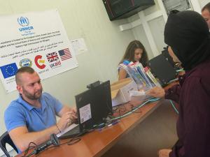 A Syrian refugee recieves her ATM card from the UN Regugee Agency (UNHCR).