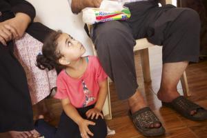 Elma, age 4, looks up at her grandfather Abdel Rahim.